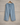 Light blue Cowrie flowers lounge embroidered linen pants against a wall